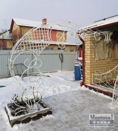 Белая металлическая садовая арка с крупными завитками и решётчатым верхом М-2