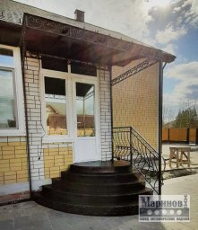 Широкий прямоугольный козырёк над крыльцом с боковой полосой завитков К-15